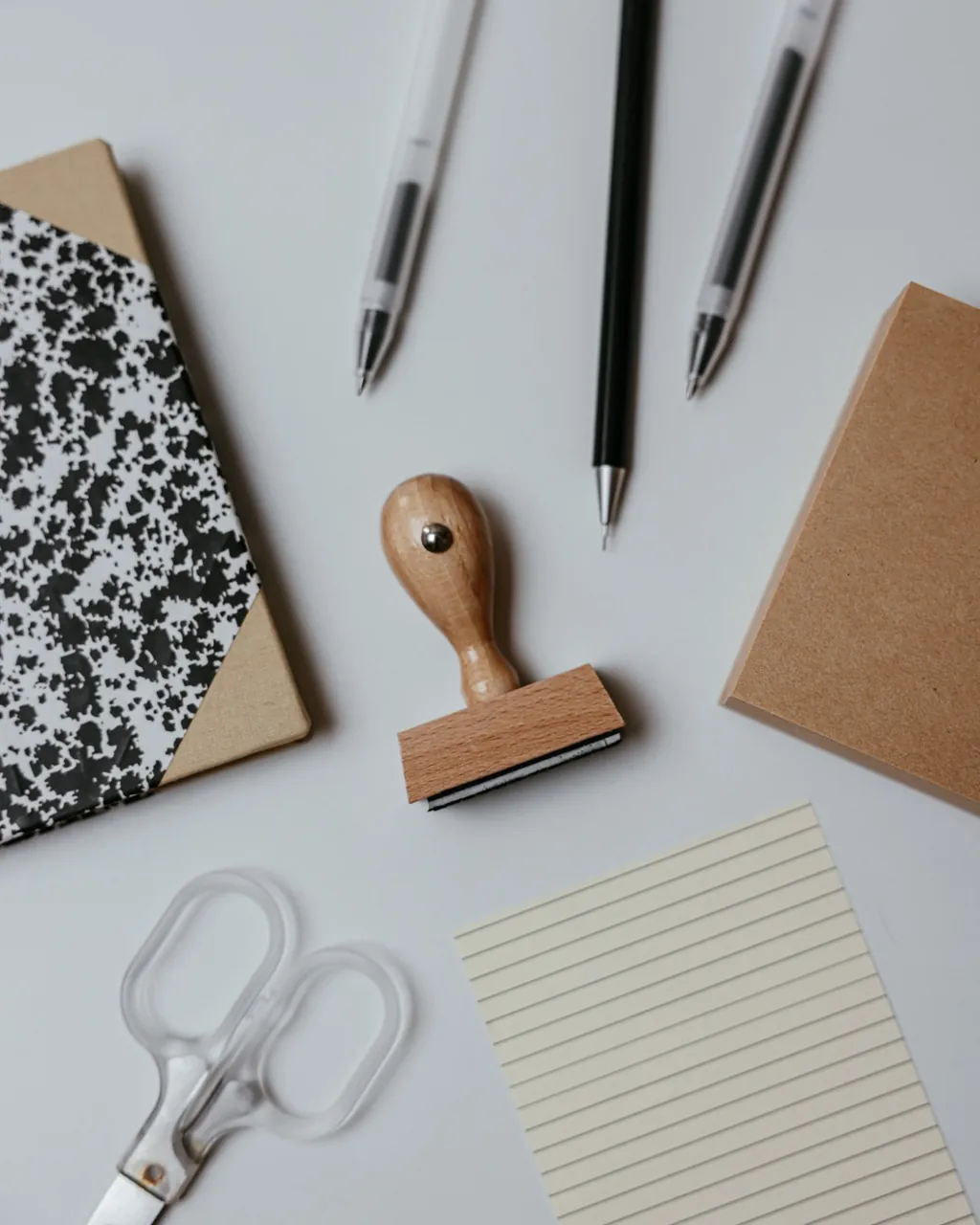 Lapiceras, sello de madera, cuaderno, papel rayado y tijera sobre el escritorio — librería y artículos de oficina para mayoristas que venden por mayor con su tienda B2B VentasxMayor